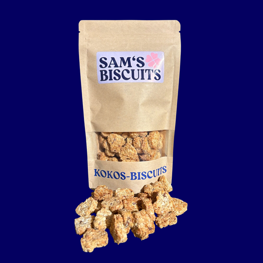 Eine 100g Tüte KOKOS-BISCUITS von SAM'S BISCUITS vor der einige besondere leckerlis für Hunde mit Kokos liegen