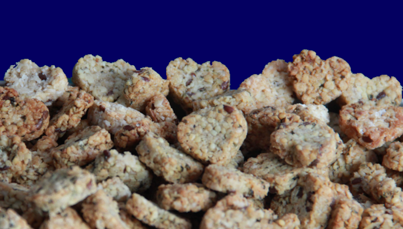 Ein Haufen hundekekse von SAM'S BISCUITS auf Haferbasis. Besondere leckerilis für Hunde in Herzform und gut duftend.