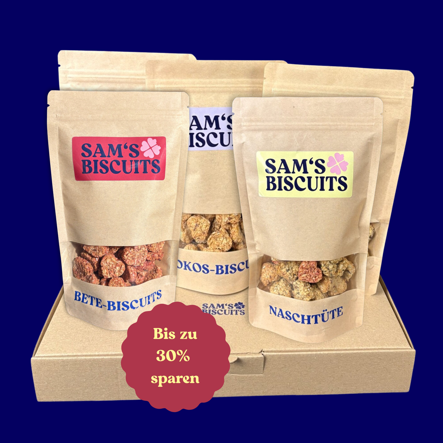 Fünf Tüten besonderer Hundeleckerlis von SAM'S BISCUITS auf einem Karton, ein roter Sticker signalisiert in diesem Angebot kannst du bis zu 30% sparen